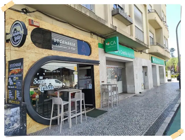 Vista da rua da Docemania na Avenida Heróis de Angola, com mesas altas na calçada portuguesa