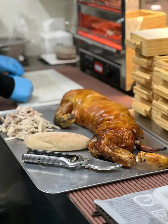 Leitão inteiro num tabuleiro, com pão e salada ao lado, pronto a servir